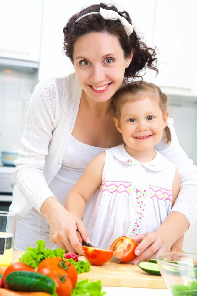 About 1 Lina Vexley - Mother and daughter cutting fresh vegetables together in a kitchen.